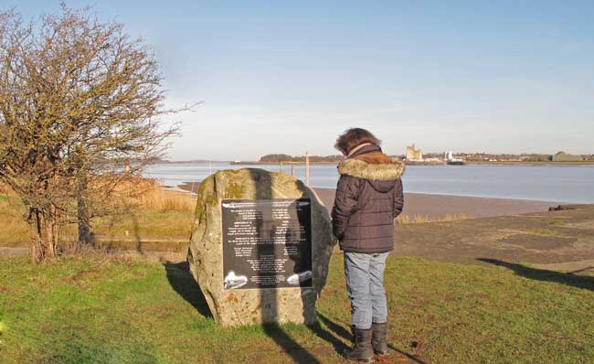 A visitor inspecting the Severn Rail Bridge memorial at Lydney Harbour.